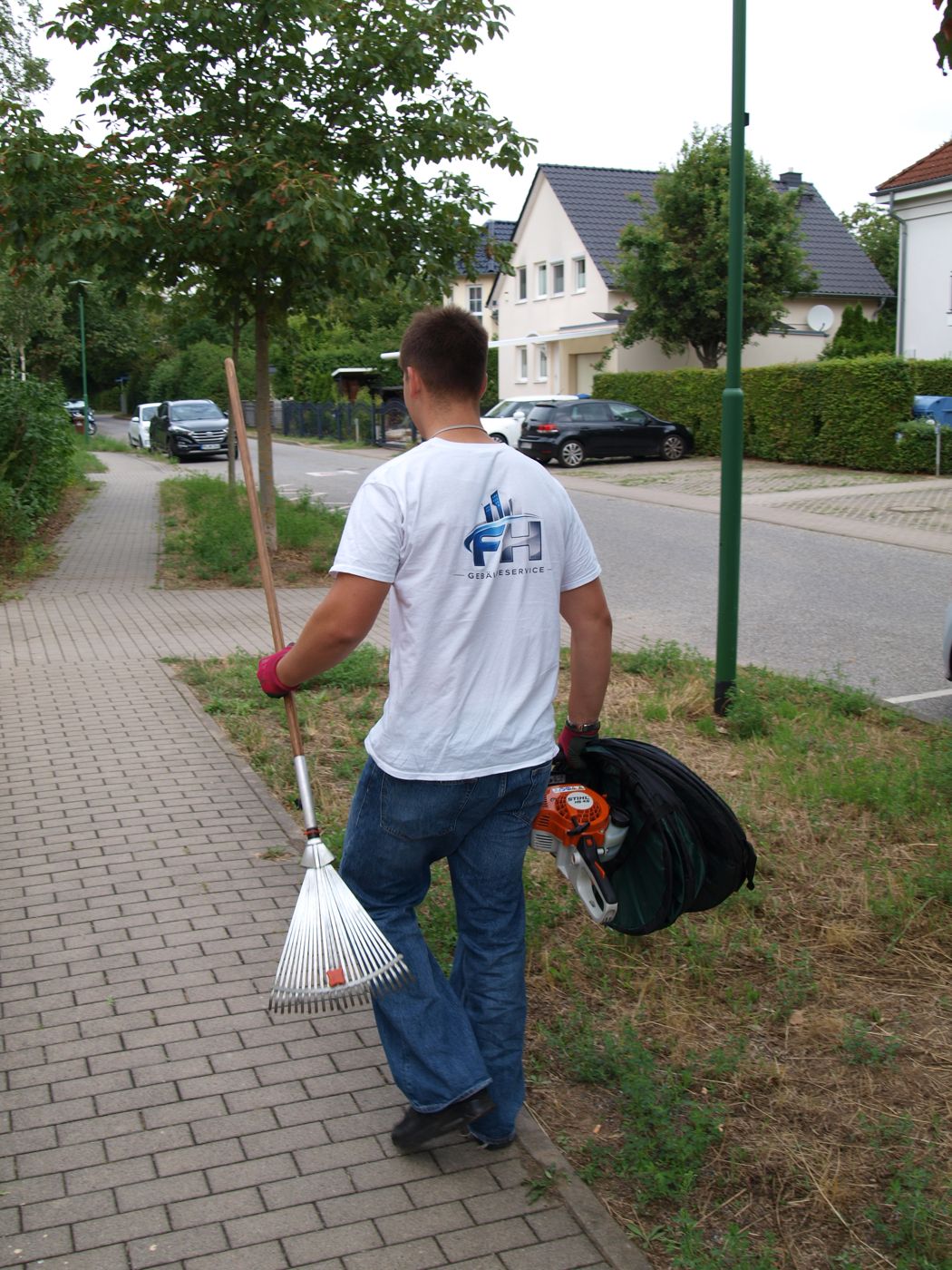Florentin Hohenstein mit Rechen und Gartensack auf dem Weg zum Einsatz